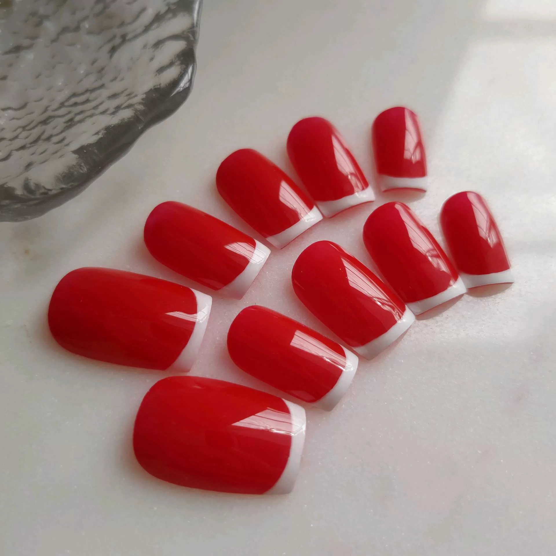 A close-up of a hand showcasing extra-long, square press-on nails featuring a clear nude base and bold black-and-white horizontally striped French tips, accented by delicate handcrafted white 3D resin roses at the smile lines. — photo 2